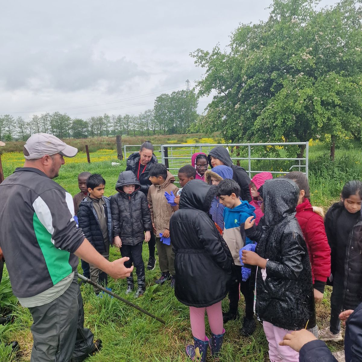 A school group learning out in the fields, rain or shine